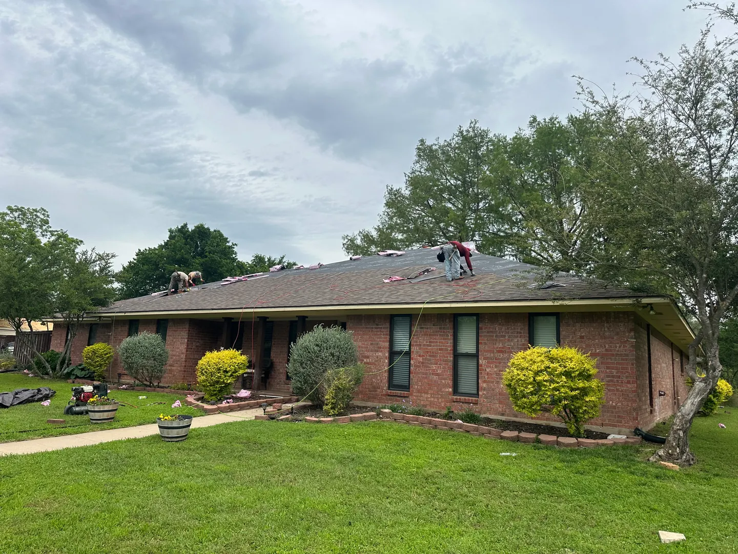 Crew installing Teak shingles on the front roof slope of the Denison home.