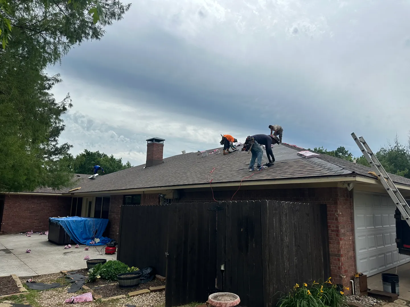 Teak shingle installation in progress above the garage and rear courtyard.